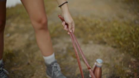 mujer turista manteniendo binoculares en el suelo en el bosque