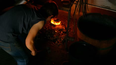 female metalsmith heating horseshoe in fire 4k