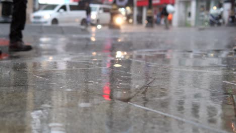 a person walking on a wet street in the city at night