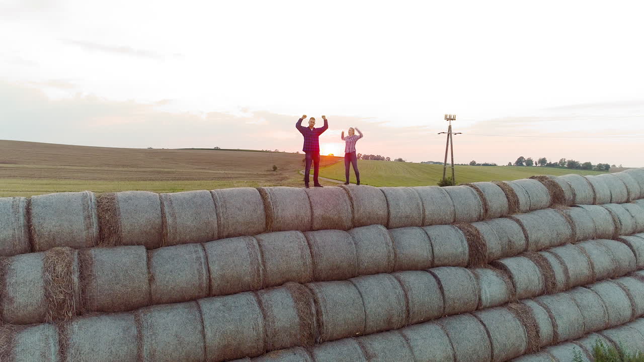 agricultores exitosos de la agricultura parados en la parte superior de un fardo de paja