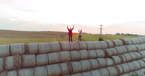 agricultores exitosos de la agricultura parados en la parte superior de un fardo de paja