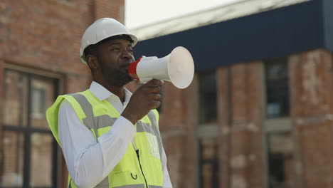 construction worker using a megaphone at a construction site
