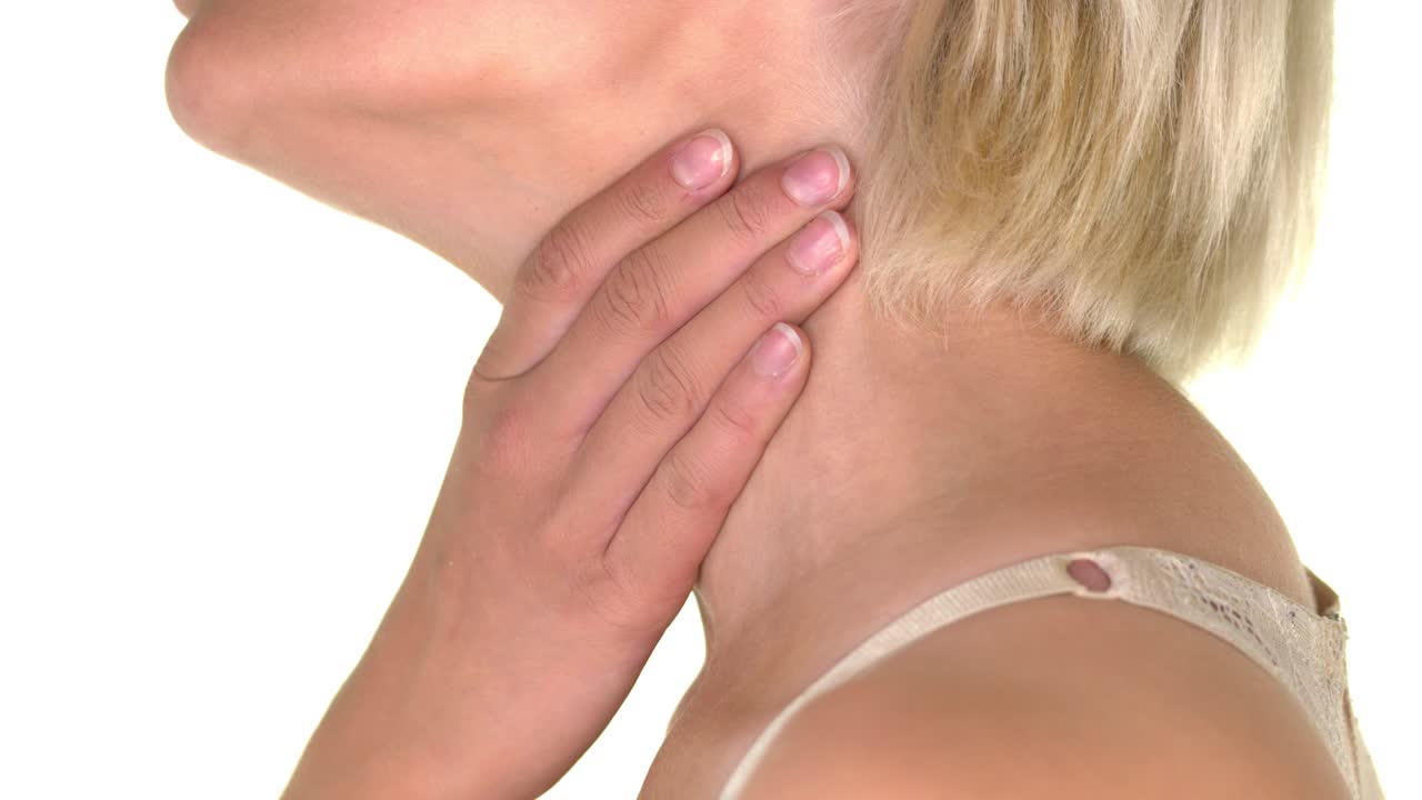 Close-up of the neck of a woman grasping her throat with her hand because of a piercing sore throat