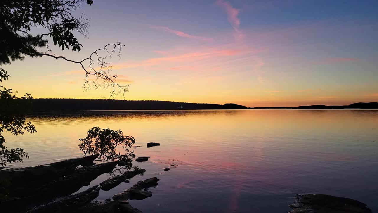 Le splendide nuvole rosa al tramonto e i riflessi in acque calme sulla costa della Columbia Britannica, Canada - Scenari crepuscolari.