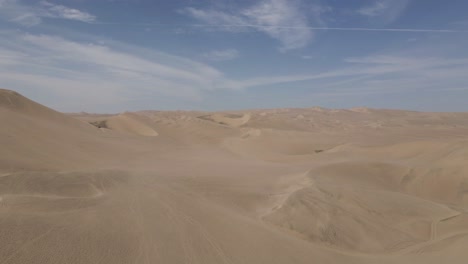 aerial rises over huge wind sculpted sand dunes in peruvian desert