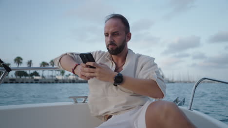 man using smartphone on a boat