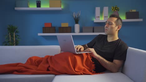 man dancing while lying down and using laptop.
