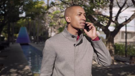 Hombre-Sonriente-Hablando-Por-Teléfono-Celular-Al-Aire-Libre