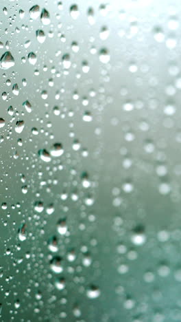 rain falling on glass during rain storm. vertical video