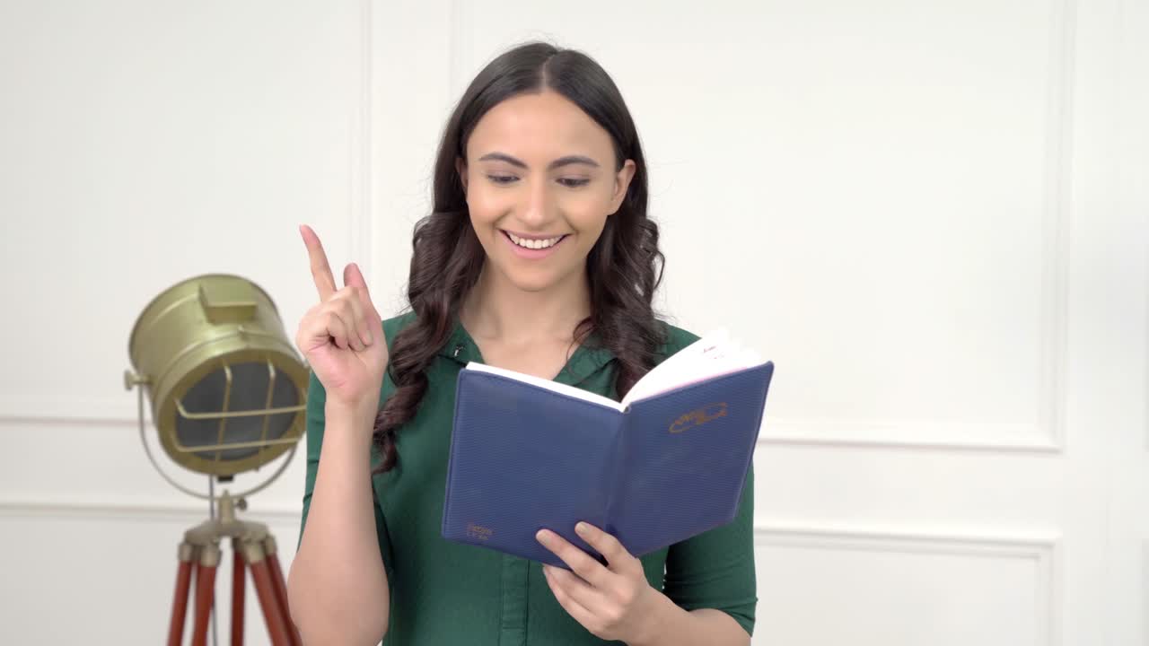 la mujer india tuvo una idea mientras leía un libro.