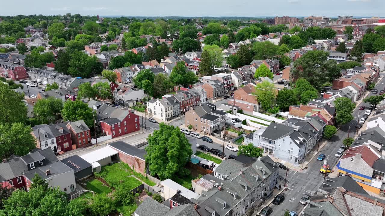Charming american city neighborhood with row of houses and green trees. Descend drone wide shot. Sunny day in spring season. Lancaster, Pennsylvania.