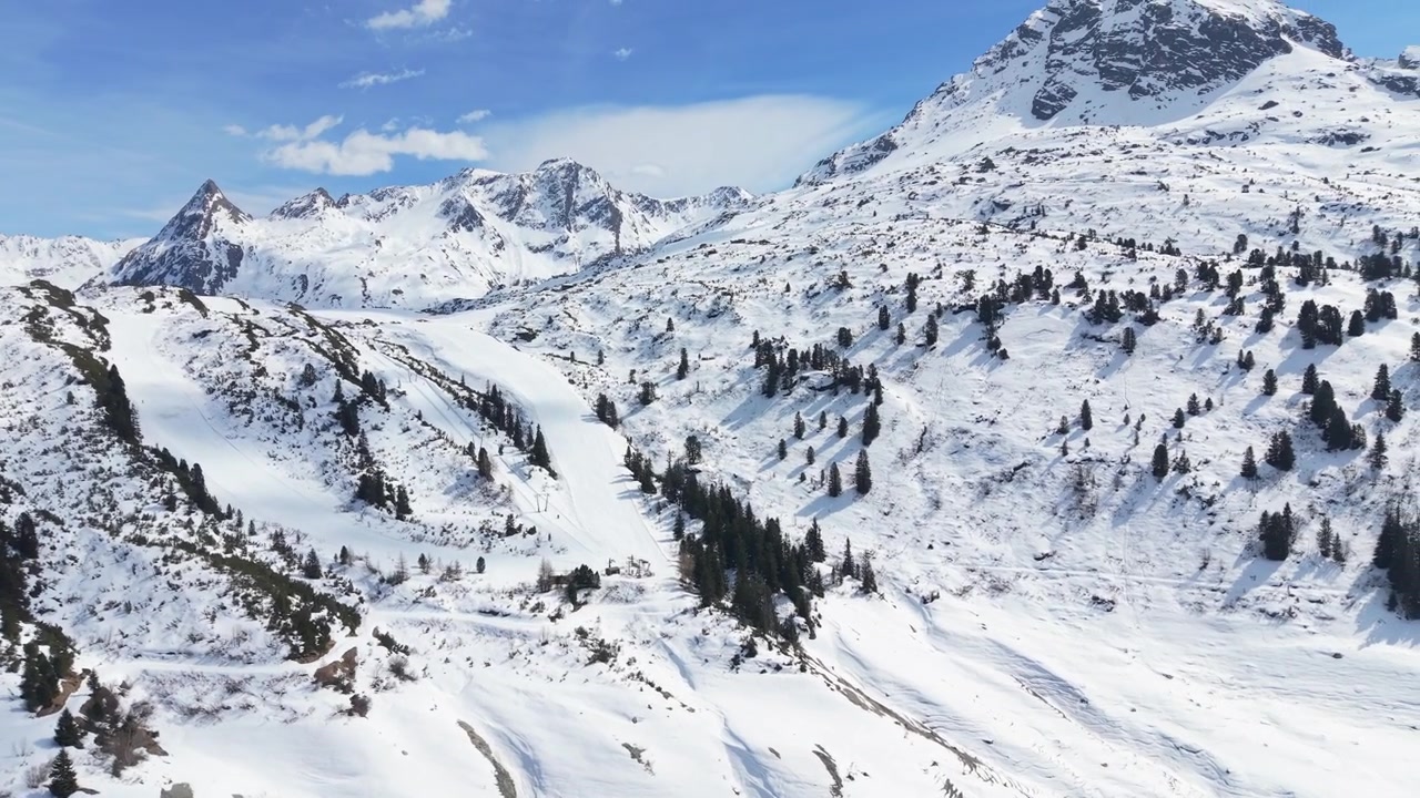 Una regione alpina innevata con una pista da sci ben definita che si snoda attraverso il paesaggio. Perfetto per promozioni di sport invernali o documentari di viaggio