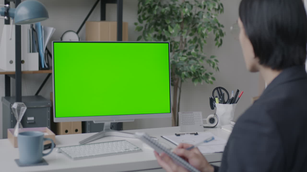 Donna d'affari che lavora al computer con schermo verde