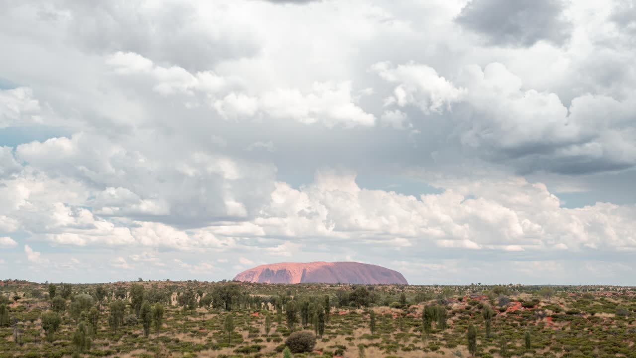 노던 테리토리(northern territory)의 울루루 카타츄타 국립공원(uluru kata-tjuta national park) 외부의 모래 언덕에서 찍은 두꺼운 구름이 울룰루를 지나고 있습니다.
