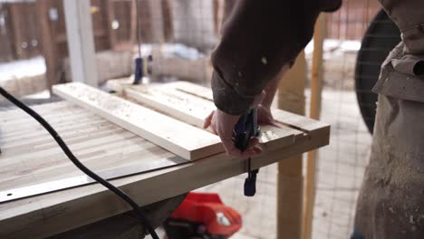 woodworker using a nail gun on slabs of wood