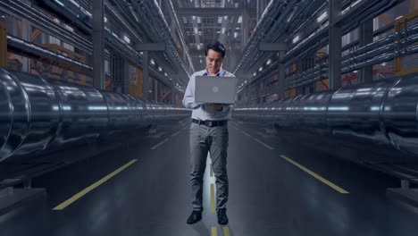 businessman working on a laptop in an industrial facility