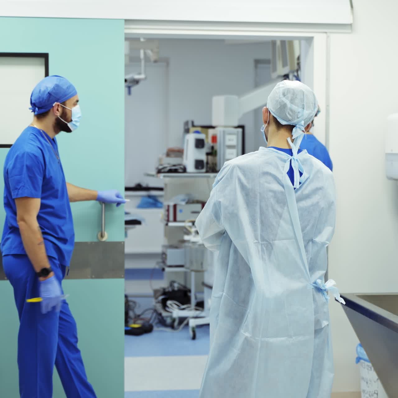 Team of surgeons before the operation. Medical workers waiting near the operating room. Doctors in medical room.
