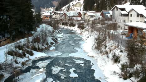 small frozen river bank in snowy landscape during wintertime