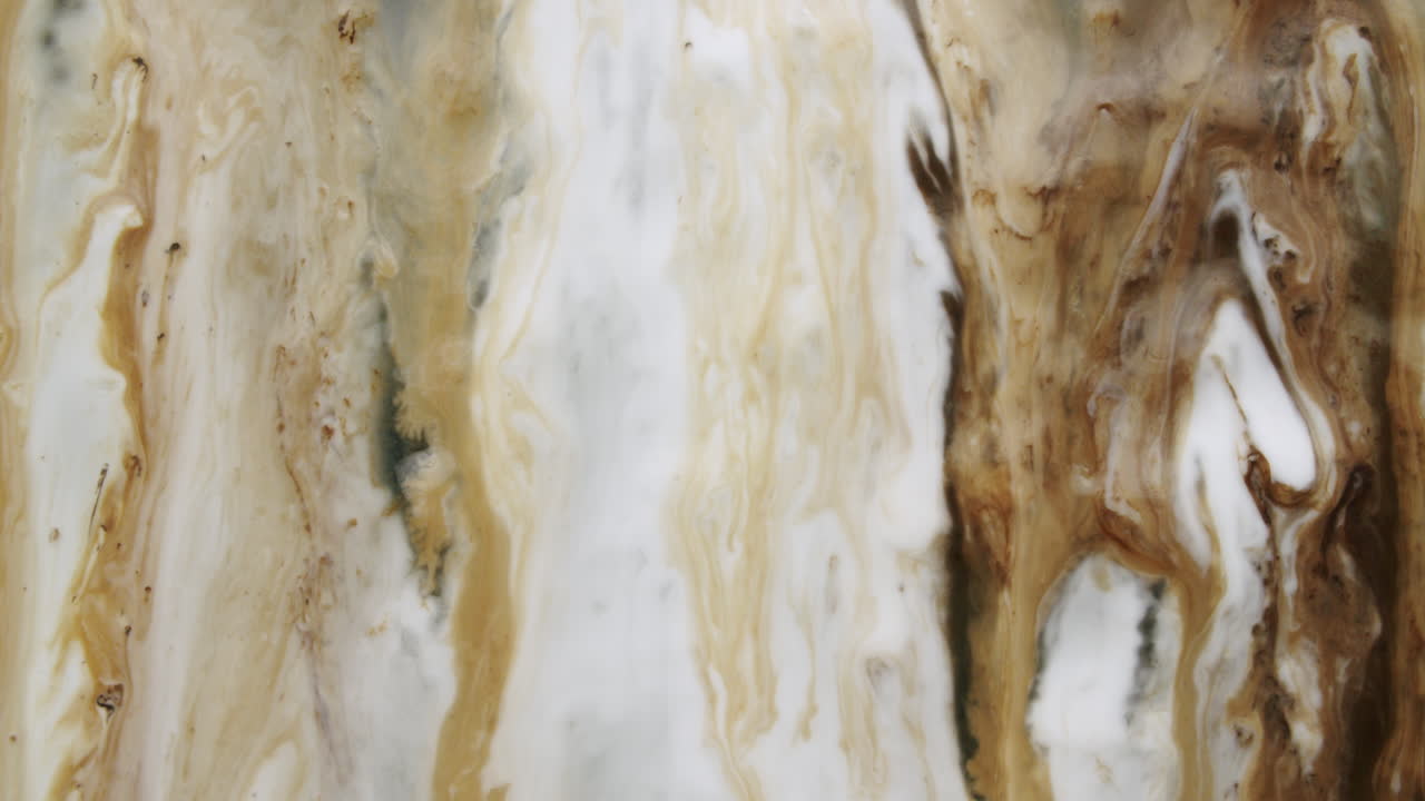 프레임 하단으로 흐르는 흰색과 금색 액체