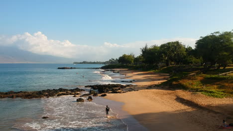 Toma-Aérea-Estilo-Dolly-Desde-Detrás-De-Una-Roca-Volcánica-Para-Revelar-La-Playa-Kamaole-Iii