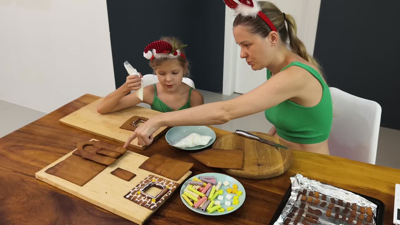 madre y hija decorando casas de pan de jengibre
