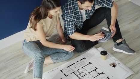 Top-view-video-of-couple-counting-the-area-of-the-new-home