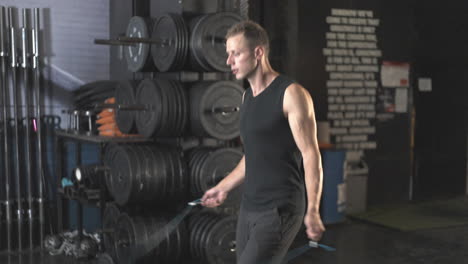 man exercising with jump rope in gym