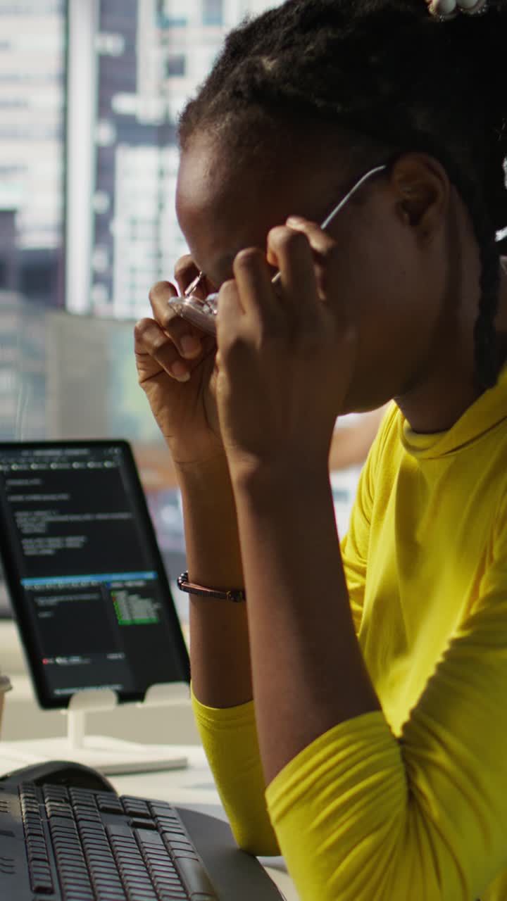 Vertical video Close up of woman at work with strained eyesight removing eyeglasses to rub eyes