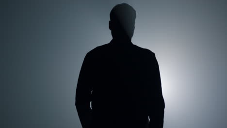 Silhouette-man-going-away-in-dark-background.-Back-view-guy-walking-in-darkness.