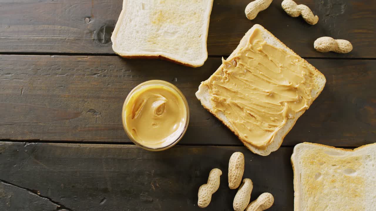 나무 배경 에 땅콩 버터 를 넣은 토스트 의 클로즈업 비디오