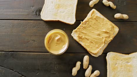 video of close up of toasts with peanut butter on wooden background