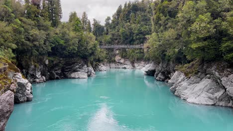 suspension bridge connecting steep, rugged river banks at hokitika gorge, new zealand