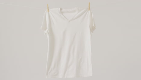 video de un primer plano de una camiseta blanca colgando sobre un fondo blanco
