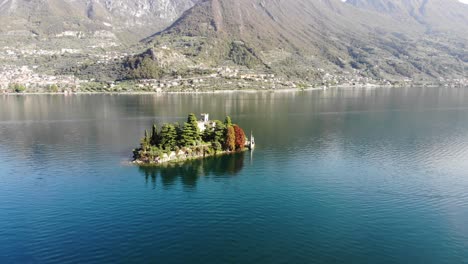 Drone-rotating-over-Isola-di-Loreto-on-Iseo-lake-revealing-the-autumn-panorama