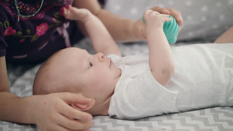 cute baby holding blue toy. newborn kid development. lovely child study world