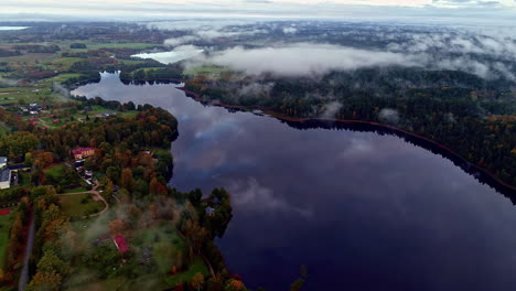 Aerial-drone-shot-of-beautiful-suburban-neighborhood-on-the-shoreline-of-a-lake-on-a-cloudy-day