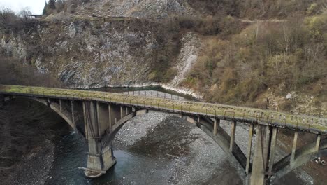 old concrete arch bridge over a mountain river