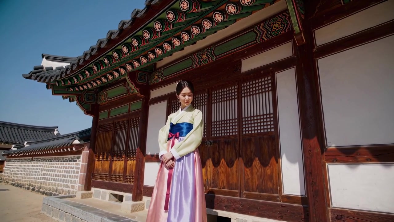 Young Woman Wearing Traditional Korean Hanbok Standing in Front of Historic Palace
