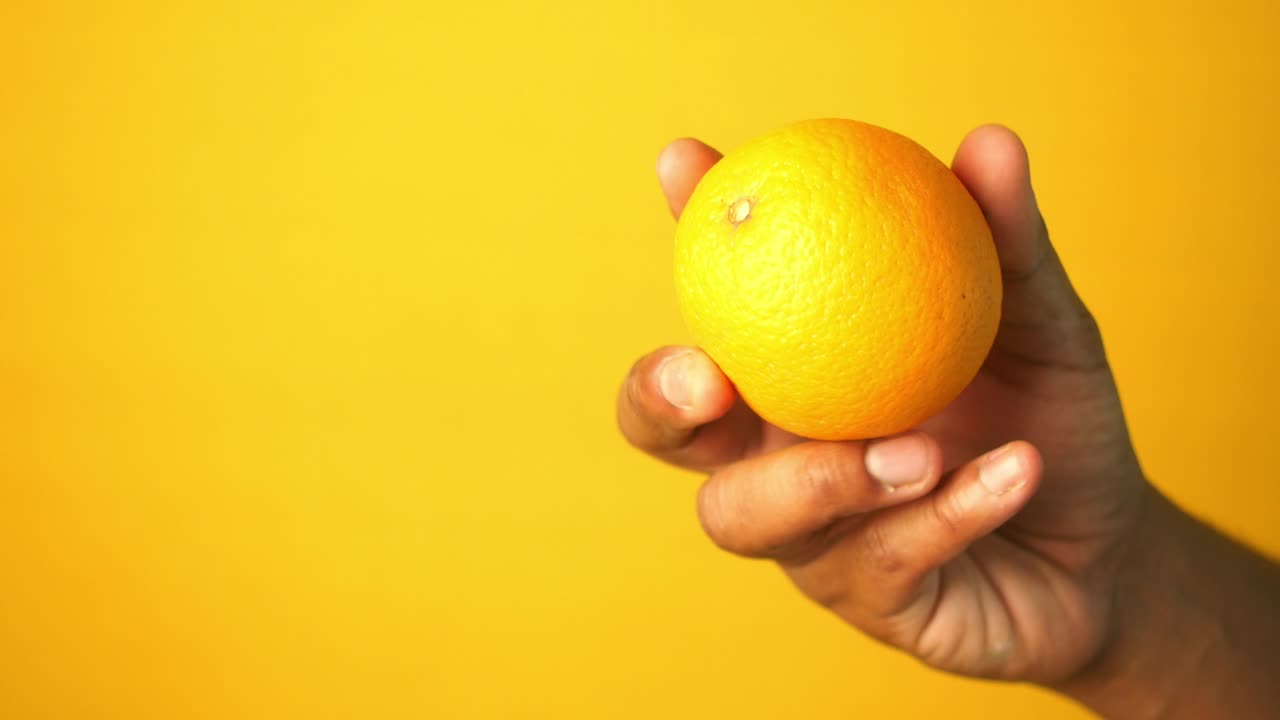 mano con una naranja