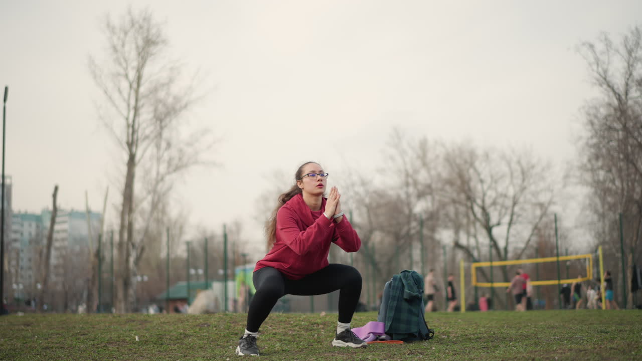 Vigorous Plyometric Training Outdoors With Backpack And Sneakers Under Cloudy Skies, Active Woman Performing Dynamic Jumping And Lunging Exercises Outside In Park During Cloudy Weather