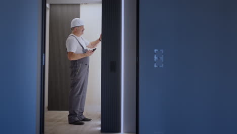 camera approaches electric checks the operation of the wall control unit of the lamps with the system of a modern house after installation and repair