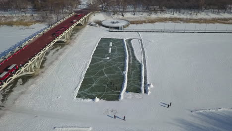 Huge-skating-rink-cleared-on-winter-river-ice,-cold-northern-city