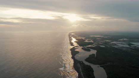 vista aérea escénica de la playa de arena negra al amanecer en el paredón, guatemala