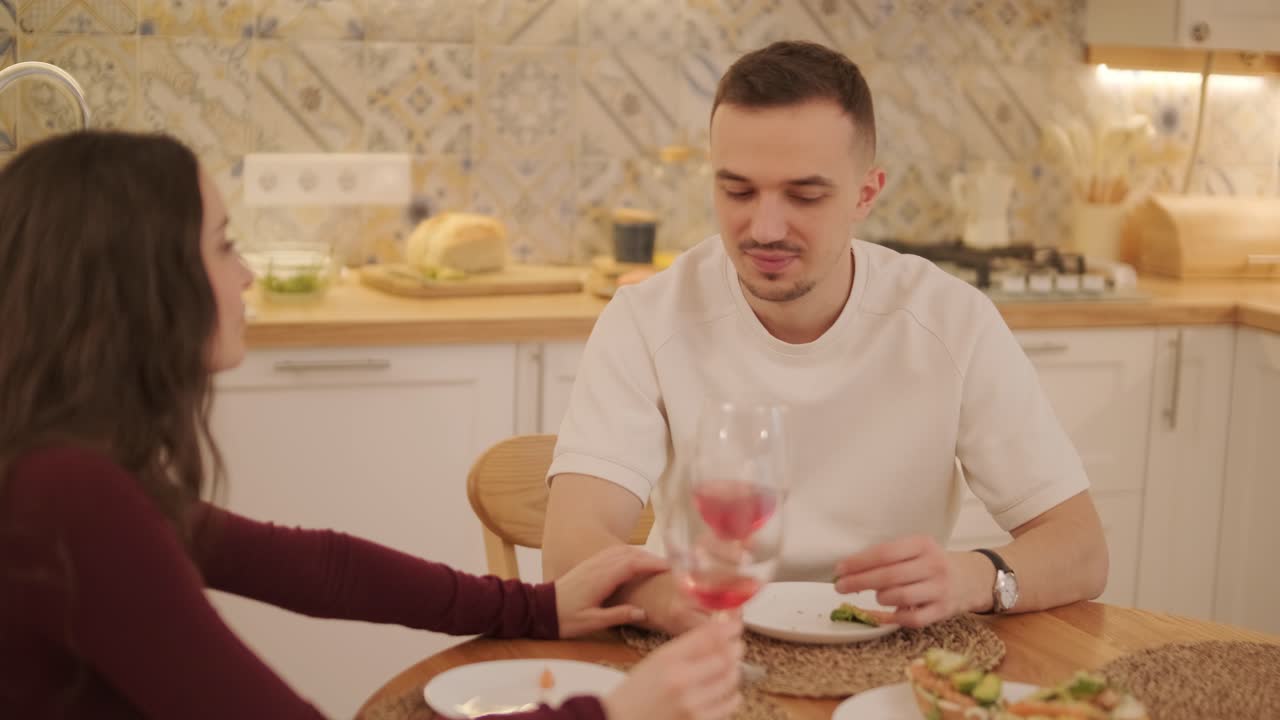 una pareja enamorada haciendo un sándwich en la cocina de la sala de estar