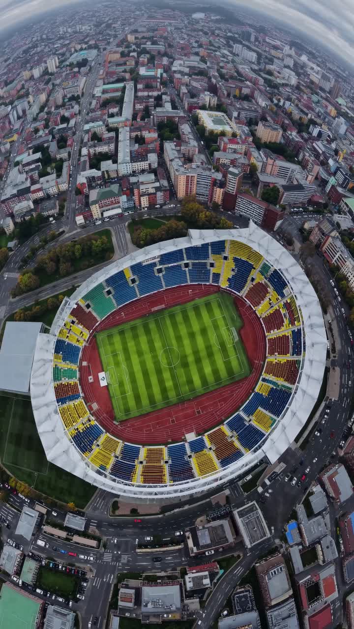 Aerial video concept of a vibrant stadium surrounded by cityscape