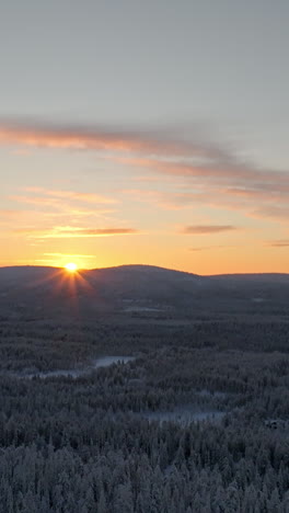 vertical aerial over a arctic winter landscape, sunrise above fells of lapland