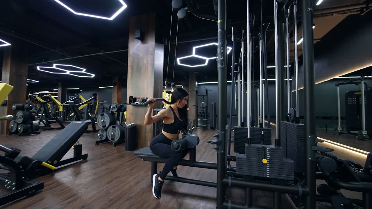 Mujer haciendo jalones al pecho en un gimnasio