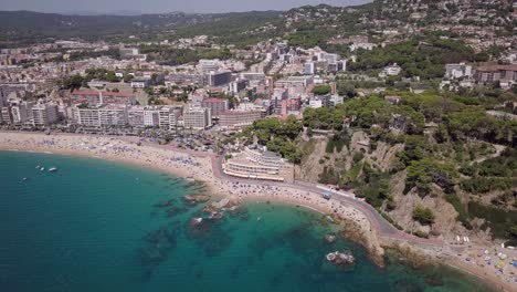 übersicht-über-Lloret-De-Mar-In-Der-Sonne-Mit-Drohnenblick-Auf-Den-Strand-Und-Das-Dorf