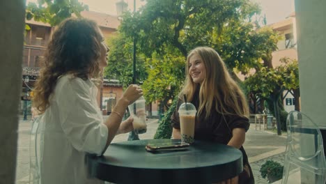 two friends enjoying bubble tea at an outdoor cafe