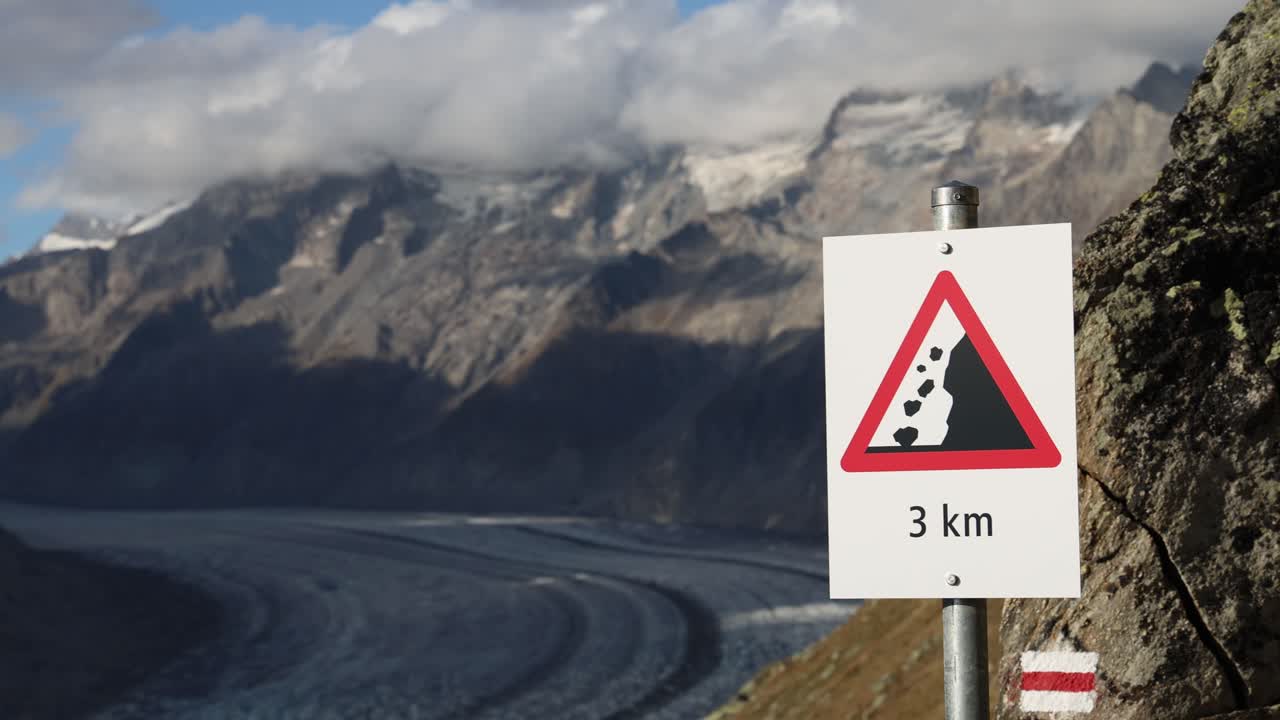 Falling rocks danger sign in the mountains, dangerous mountain path